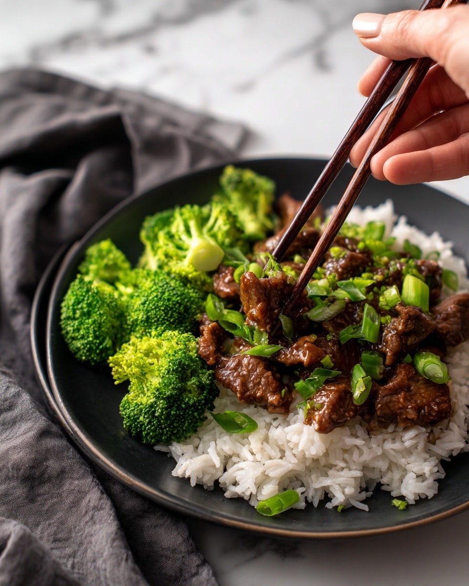 A close-up of a black plate shows three layers: the bottom layer is white rice with visible grains, the middle layer consists of bright green broccoli florets, and the top layer includes brown, saucy pieces of beef mixed with chopped green onions. A woman's hand is holding dark brown wooden chopsticks picking up a piece of beef. The plate is placed on a white marbled surface with a dark gray cloth nearby. Photo taken with an iphone --ar 4:5 --v 7