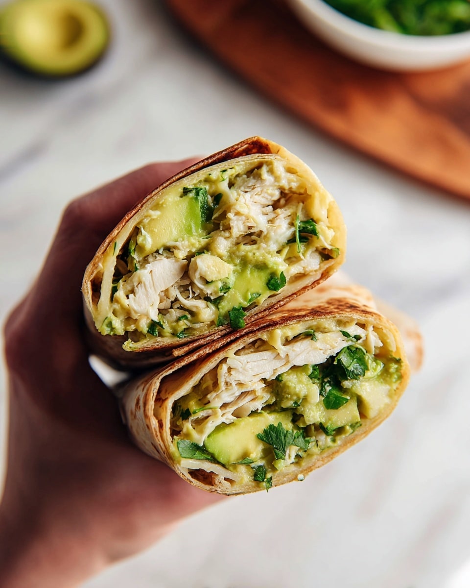 The image shows a white plate holding five grilled wraps cut in half, stacked in a pyramid shape. Each wrap has a browned, slightly crispy outer tortilla layer. Inside the wraps, there are visible layers of light beige sliced chicken, chunky pale green avocado, and some shredded yellow cheese mixed with bits of green vegetables. A wedge of lime is placed on the plate beside the wraps. A woman's hand is holding the top wrap, lifting it slightly. The setting has a white marbled surface background with bowls of green herbs and sauce around the plate. Photo taken with an iphone --ar 4:5 --v 7