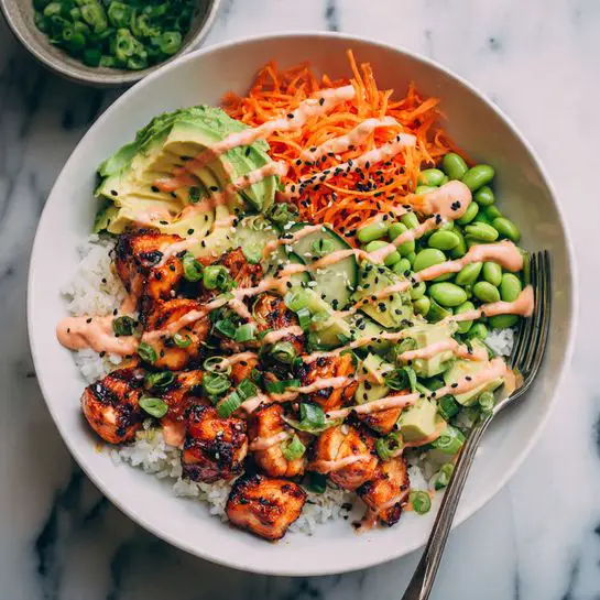 A white bowl filled with a layered dish starting with a base of white rice. On top, sections of bright orange shredded carrot, green edamame beans, cubed light green avocado, and diced dark green cucumber sit neatly around the bowl. In the center are golden-brown grilled chicken pieces, drizzled with a light pink creamy sauce and sprinkled with black and white sesame seeds and small slices of green onion. A silver fork rests inside the bowl on the right side. The bowl is placed on a white marbled surface, surrounded by other bowls filled with shredded carrot and edamame beans. Photo taken with an iphone --ar 4:5 --v 7