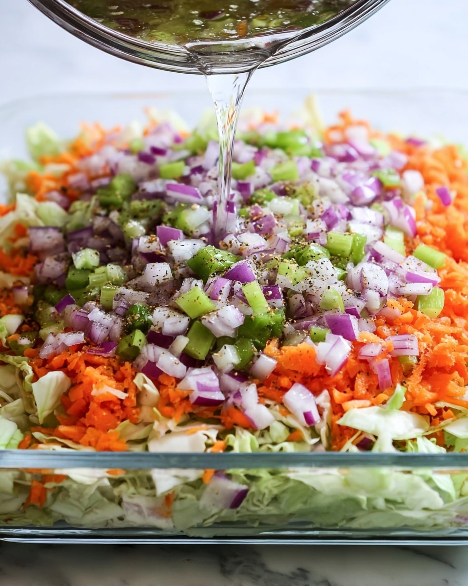 This image shows a clear glass dish filled with multiple layers of chopped vegetables. The bottom layer is light green and white, possibly cabbage or lettuce. On top of that is a layer of shredded bright orange carrots. The top layer is a mix of small diced vegetables, including purple and white onions, green scallions, and green bell peppers, sprinkled with black pepper or seasoning. A clear liquid is pouring over the vegetables from above. The dish sits on a white marbled surface. photo taken with an iphone --ar 4:5 --v 7