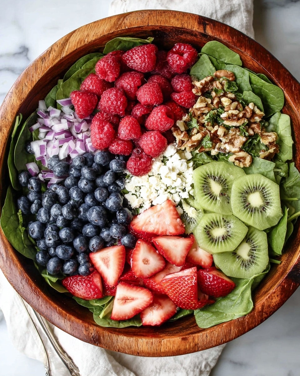 A large wooden bowl filled with layers starting from the bottom with green spinach leaves, topped with separated clusters of bright red raspberries, dark blue blueberries, light green kiwi slices, white cottage cheese, red strawberry pieces, thin purple onion slices, and brown crunchy nuts on one side. A woman's hand is pouring a creamy light pink dressing over the blueberries in the center. The bowl is placed on a white marbled surface, with two tall clear glasses of ice water with blueberries inside and a wooden board with scattered berries blurred in the background. Photo taken with an iphone --ar 4:5 --v 7