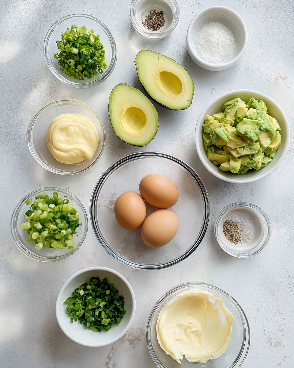 The image shows several white bowls arranged on a white marbled surface, each containing different ingredients. There are two clear glass bowls in the center, one holding three brown eggs and the other holding two halves of a green avocado with the pits removed. Around these bowls are smaller white bowls with chopped green herbs, finely chopped green onions in two sizes, a dollop of light mustard, a scoop of light yellow mayonnaise, a small amount of clear liquid, coarse salt, and ground black pepper. The colors vary from light yellow, green, brown, and white, with the textures ranging from smooth avocado flesh to the creamy sauces and coarse seasonings. Photo taken with an iphone --ar 4:5 --v 7