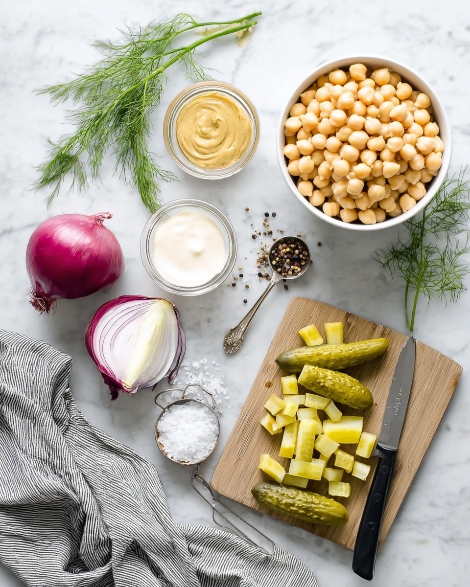 The image shows a top-down view of cooking ingredients on a white marbled surface. A white bowl filled with light yellow chickpeas is in the top right. Below it is a small wooden cutting board with sliced green pickles arranged in two rows, some diced pickles, and a knife with a black handle resting on the board’s right edge. To the left of the board, there is a halved red onion with green sprouts lying on a gray-striped fabric. Nearby are three small glass bowls: one with a mustard-colored sauce, one with a white creamy sauce, and one with a clear liquid. Fresh green dill sprigs are scattered around, along with a metal measuring spoon containing salt and some spilled black pepper. The scene is evenly lit, clean, and neatly organized photo taken with an iphone --ar 4:5 --v 7