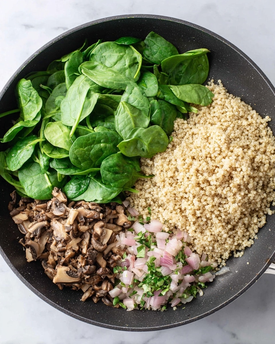 This image shows a black pan placed on a white marbled surface, filled with four main layers arranged separately. On the right side, there is a large mound of light beige quinoa with small, rounded grains that look soft and fluffy. To the left of the quinoa, there is a pile of fresh green spinach leaves, fresh and smooth with visible veins and stems. Below the spinach, finely chopped mushrooms with a mix of dark brown and beige colors are grouped together, showing a slightly rough texture. Next to the mushrooms are tiny diced pieces of pale pink onion mixed with some small green herb leaves. All these layers are sitting in the pan without mixing, showing clear groupings and variety in texture and color. Photo taken with an iphone --ar 4:5 --v 7