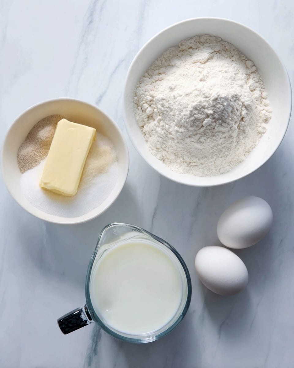 A white bowl contains a mixture of white sugar, a stick of yellow butter, and small amounts of white and light brown powders, all lying at the bottom. To the bowl’s top right is another white bowl filled with off-white flour heaped loosely inside. Below the flour bowl is a clear measuring jug filled with fresh white milk, its handle black and silver. To the right of the jug are two whole white eggs with smooth shells. All items are placed on a white marbled surface. Photo taken with an iphone --ar 4:5 --v 7