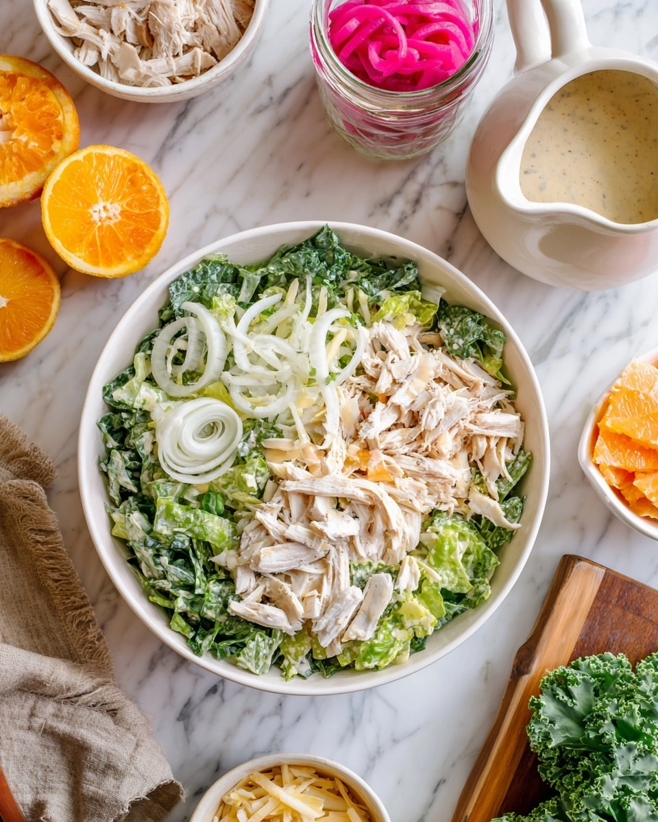 A white bowl filled with layered salad sits on a white marbled surface. The bottom layer has dark green kale leaves mixed with lighter green romaine lettuce. Above the greens, there is a layer of thinly sliced white fennel. The top layer is shredded pale chicken. Around the bowl, there are small white bowls containing more shredded chicken, orange slices, sliced fennel, and a beige pitcher with white dressing. A glass jar with red pickled onions and a wooden cutting board with kale leaves are also visible nearby. Photo taken with an iphone --ar 4:5 --v 7