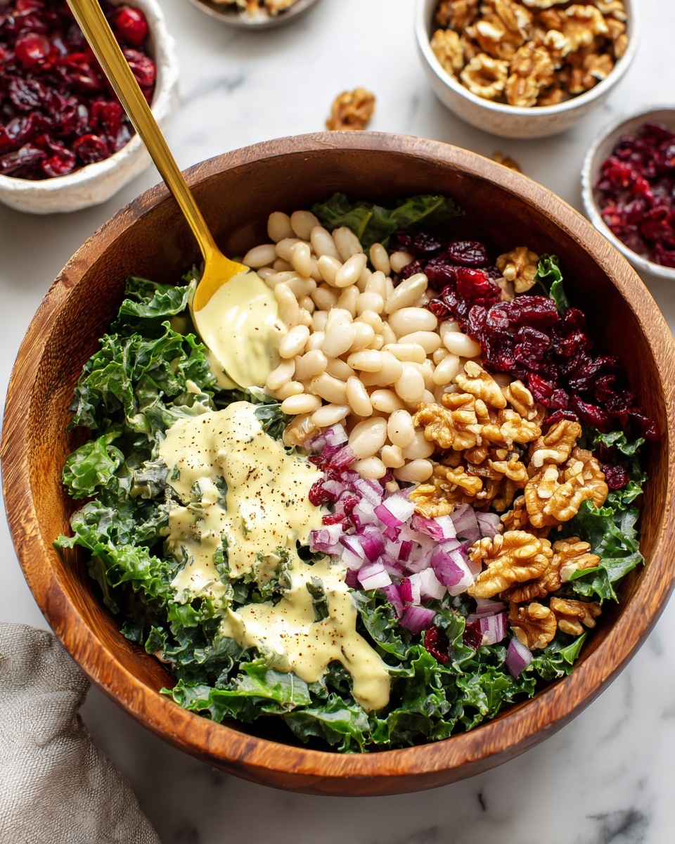 A wooden bowl holds a colorful layered salad starting with a base of green kale that covers most of the bowl bottom. On top of the kale, there are scattered white beans with a soft texture, sprinkled with cracked black pepper. Around the edges and mixed in, there are small pieces of chopped red onion, rough walnut chunks, and dried red cranberries adding pops of deep burgundy and light purple. Dollops of creamy pale yellow dressing with specks are spread unevenly over the salad. A gold spoon rests inside the bowl. The bowl is placed on a white marbled surface, with small white bowls of dried cranberries and walnuts visible in the background. Photo taken with an iphone --ar 4:5 --v 7