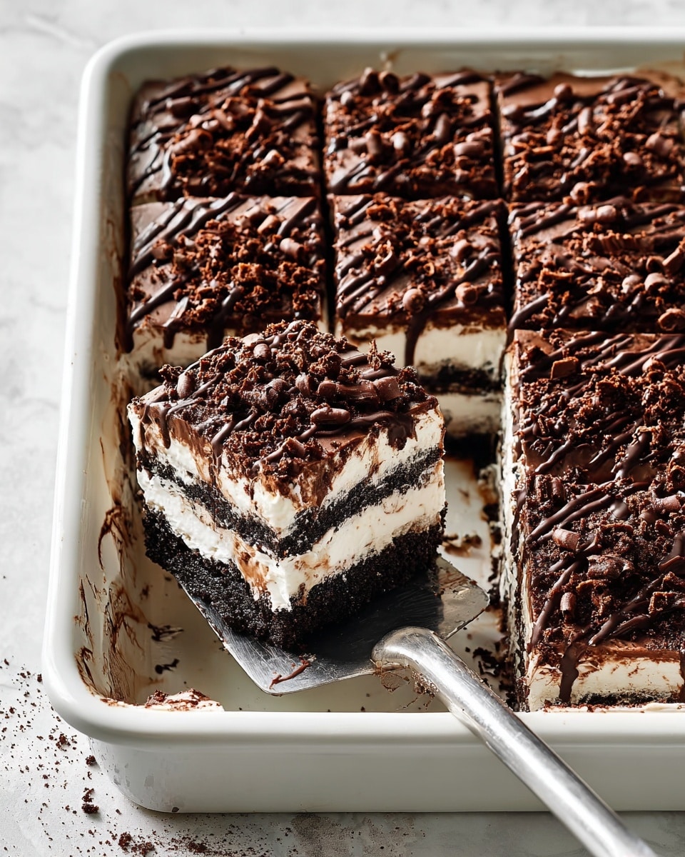 The image shows a square slice of layered dessert on a white plate with a delicate rim pattern, placed on a white marbled surface. The dessert has four visible layers: a dark crumbly chocolate base, a thick creamy white layer on top of it, then a smooth milk chocolate layer above the cream, and finally a top layer of dark chocolate crumbs mixed with chocolate shavings and drizzle giving it a rich textured look. Some crumbs are scattered around the plate, adding a casual touch. Photo taken with an iphone --ar 4:5 --v 7