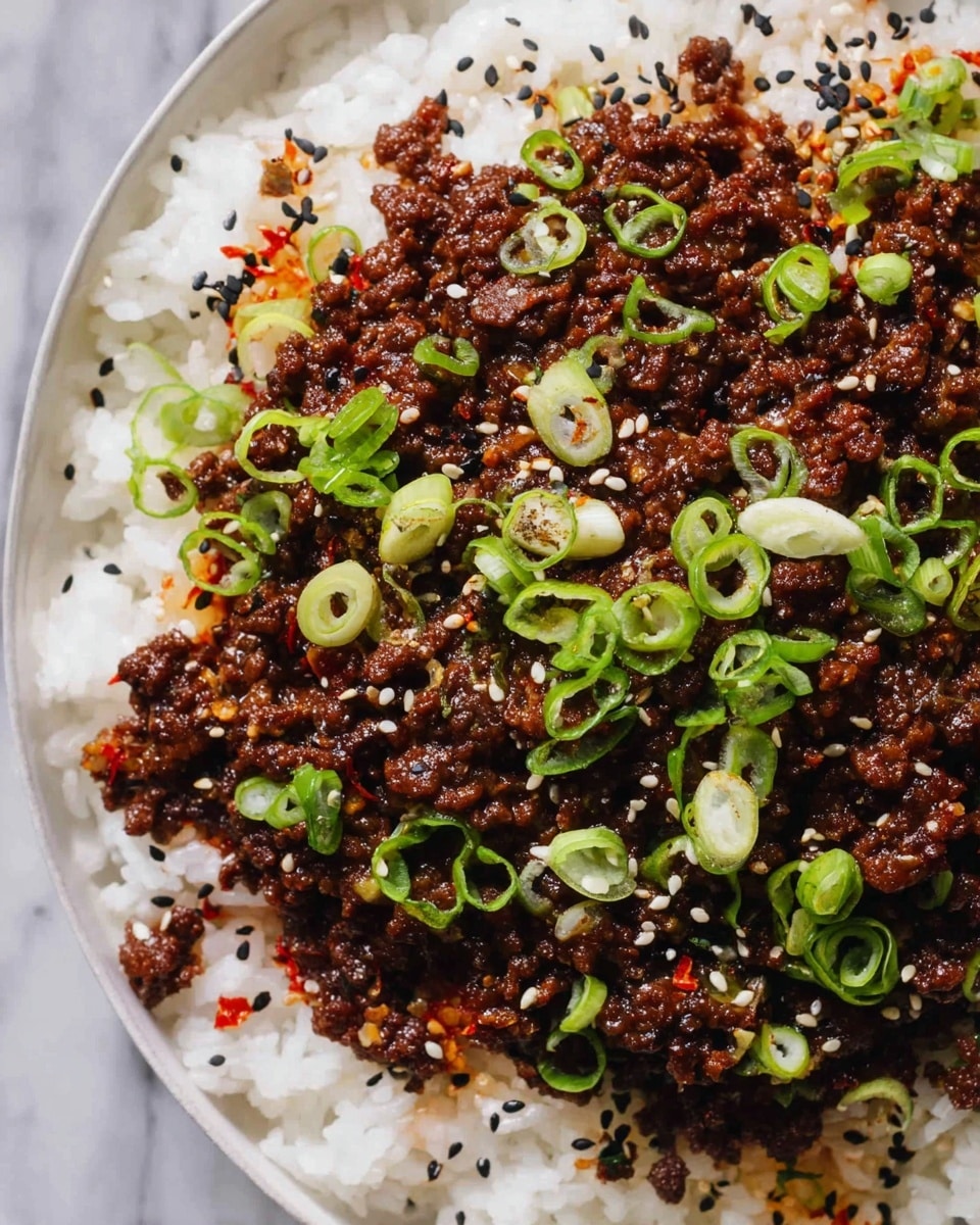 This image shows a close-up of a dish with two main layers inside a white bowl. The bottom layer is made of white rice with soft, fluffy grains. On top, there is a thick layer of dark brown cooked minced meat with small bits of cooked onions mixed in. The minced meat is garnished with fresh green sliced spring onions scattered evenly and mixed white and black sesame seeds sprinkled all over. There are also tiny red chili flakes adding small spots of red color. The bowl sits on a white marbled surface. photo taken with an iphone --ar 4:5 --v 7