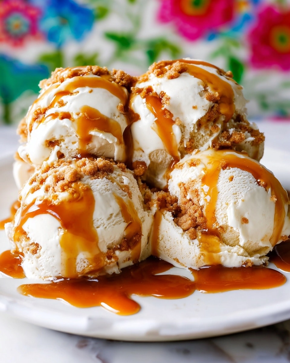 The image shows a close-up of at least six creamy vanilla ice cream scoops arranged closely on a white plate. Each scoop has a smooth light beige texture and is generously drizzled with thick, shiny caramel sauce that cascades down the sides in rich amber tones. There are crumbly pieces of a golden brown cookie or cake mixed within the ice cream, adding extra texture. The background is a clean white marble surface with subtle veining. In the foreground, part of a shiny gold spoon rests on the marble surface, adding a touch of elegance. photo taken with an iphone --ar 4:5 --v 7