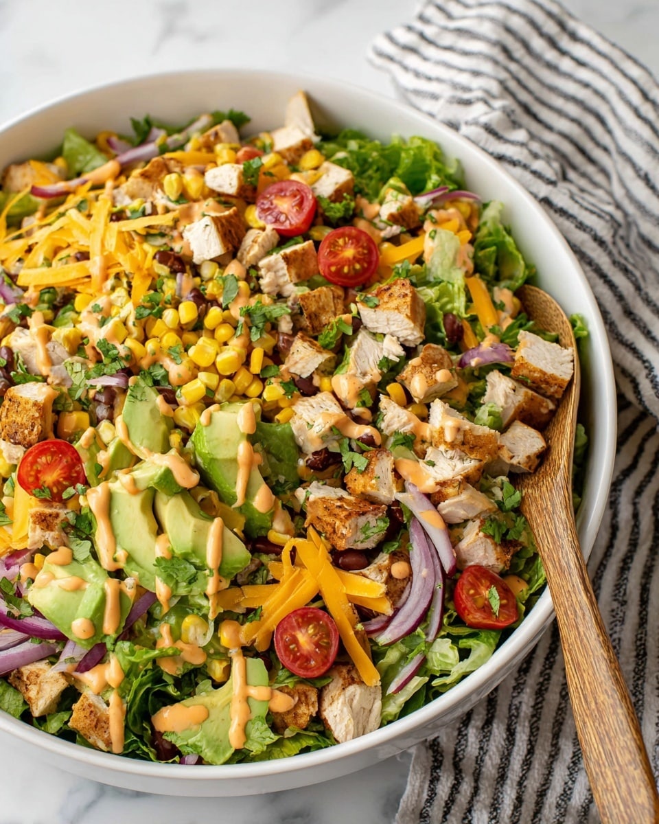 A blue bowl holds a colorful salad with several layers: the base is made of fresh, green spinach and lettuce leaves, scattered with yellow corn kernels and small black beans. On top, there are chunks of grilled chicken with a light brown grilled texture, slices of bright red cherry tomatoes, thin white onion strips, and small diced pieces of fresh green avocado. The salad is lightly drizzled with a creamy orange dressing that spreads softly over the top, all placed on a white marbled surface next to a gold fork and a white and green striped cloth. Photo taken with an iphone --ar 4:5 --v 7