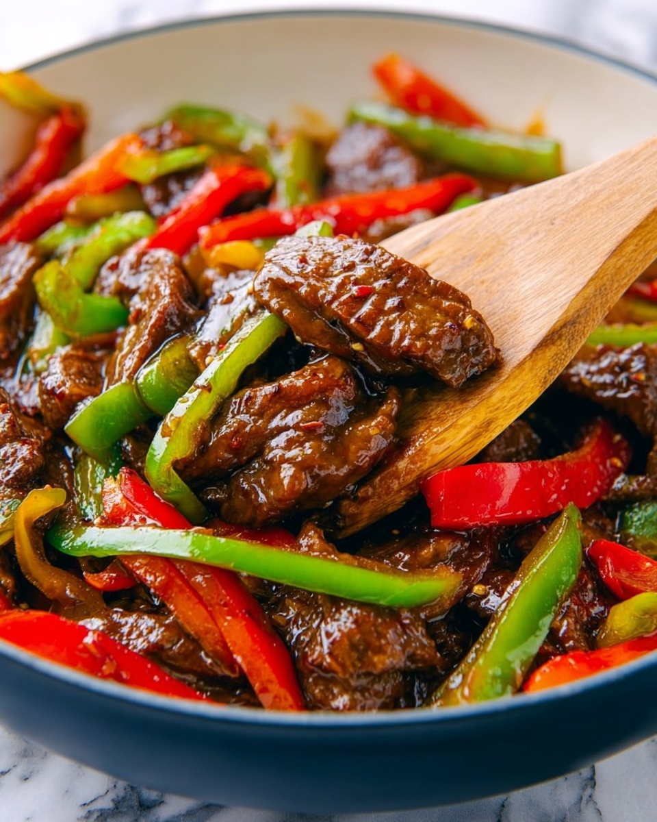 The image shows a close-up of a stir-fry dish in a white bowl with a dark blue edge, filled with glossy, dark brown pieces of cooked meat mixed with bright red and green sliced bell peppers. A light wooden spatula is in the bowl, lifting a piece of meat and some green pepper strips. The surface under the bowl is a white marbled texture. The meat looks tender and covered in a shiny dark sauce, while the peppers are fresh and crisp. photo taken with an iphone --ar 4:5 --v 7