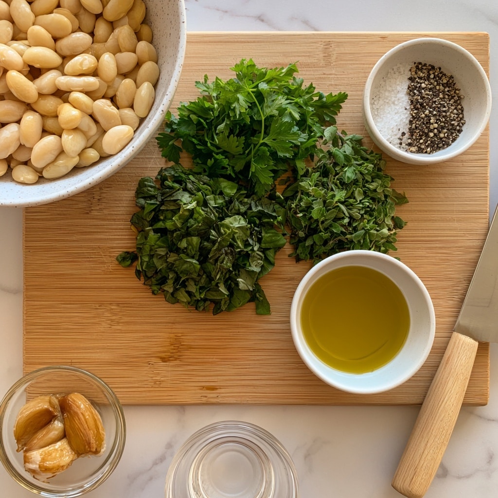 A white speckled bowl filled with pale yellow-white beans sits on the upper left of a light wooden cutting board. On the board, three piles of chopped herbs lay in the center: bright green parsley on top, darker green basil below it, and medium green oregano on the right. To the right of the herbs is a small white bowl holding sea salt and coarsely ground black pepper. Below the herbs on the board, a white bowl contains golden yellow olive oil. In the lower left corner, a small clear glass bowl holds three cloves of light brown roasted garlic. Below the cutting board is a small clear glass bowl with water. A knife with a light wooden handle lies horizontally on the right side of the cutting board against a white marbled surface photo taken with an iphone --ar 4:5 --v 7