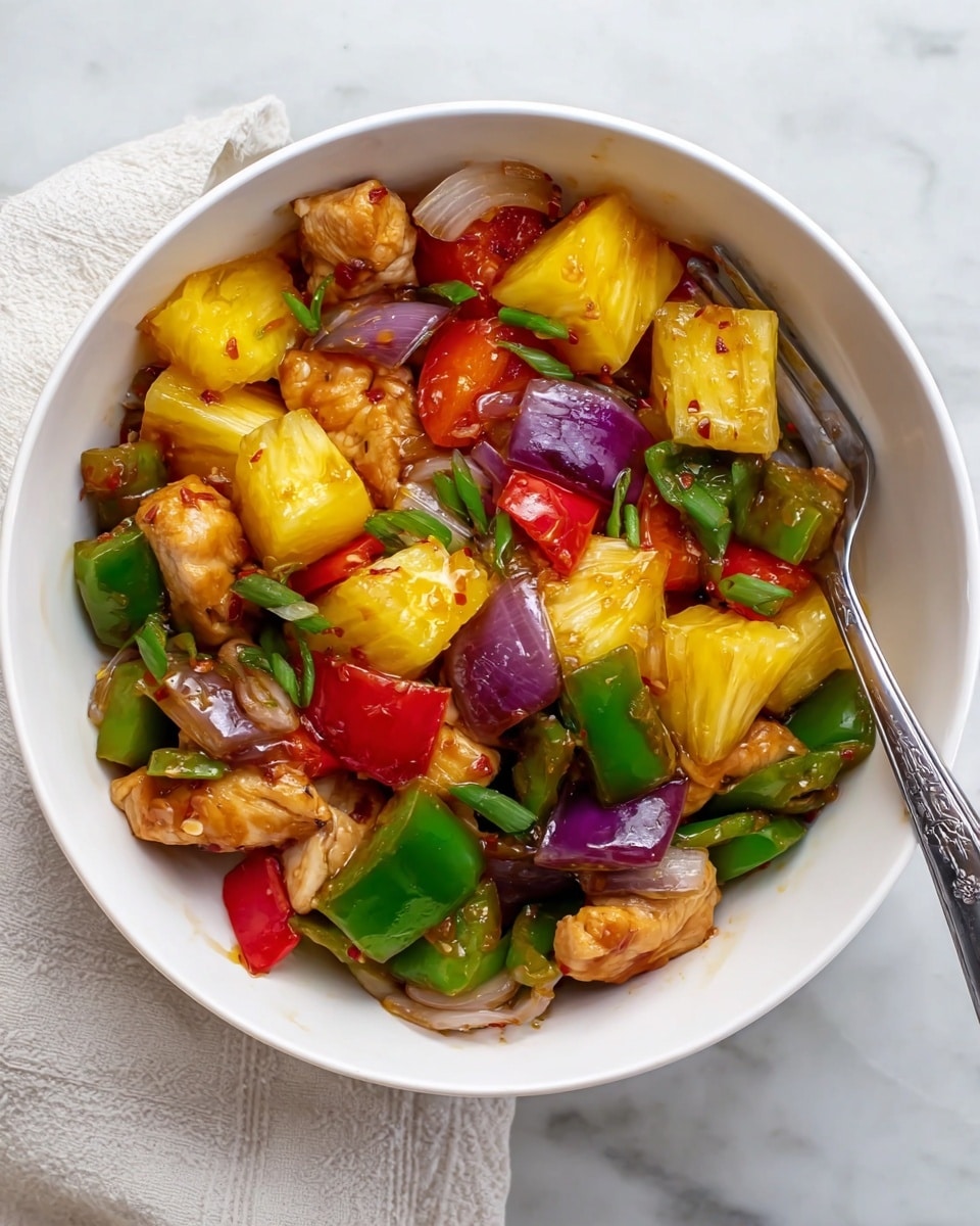 A white bowl filled with a colorful mix of ingredients including yellow pineapple chunks, green and red bell pepper pieces, purple onion segments, and glossy pieces of marinated chicken, all coated lightly in a shiny sauce. The ingredients are mixed together, showing a blend of bright yellows, greens, reds, purples, and light brown chicken bits. A silver fork rests inside the bowl on the right side, and the bowl sits on a white marbled surface with a light cloth partially visible underneath. photo taken with an iphone --ar 4:5 --v 7